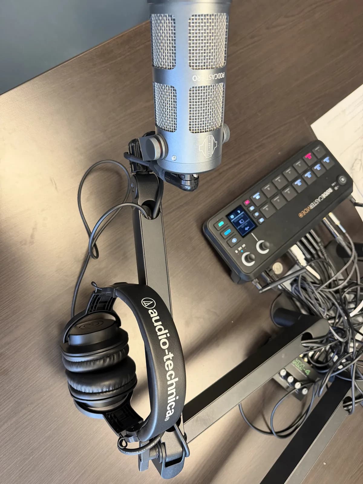 Close view of podcast studio production gear and connected audio equipment.