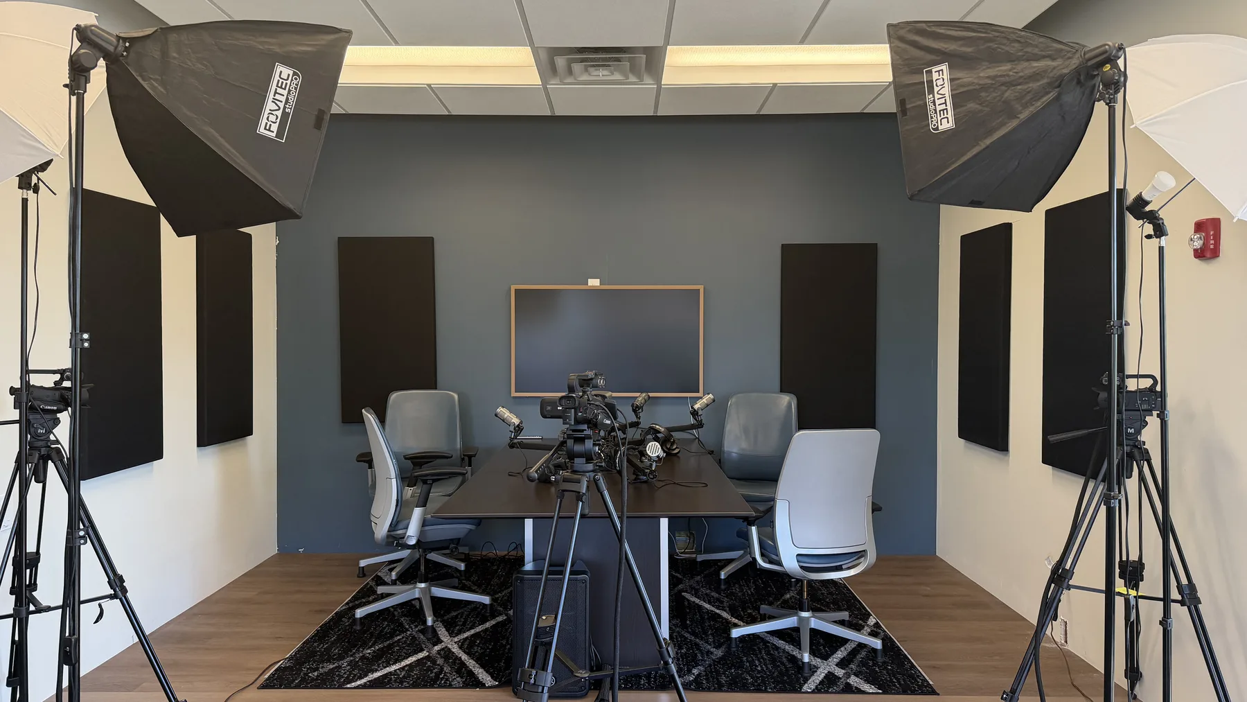 New Reward podcast studio with cameras, lights, microphones, chairs, and acoustic panels.